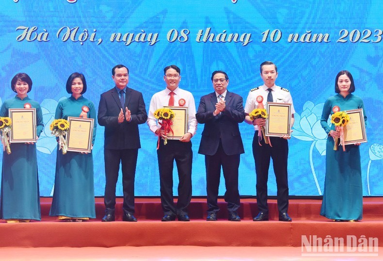 El primer ministro de Vietnam, Pham Minh Chinh, entrega certificados de mérito a los individuos por sus destacadas iniciativas.