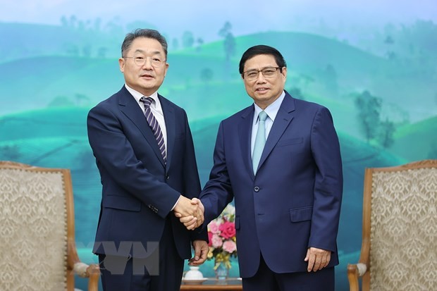 El primer ministro de Vietnam, Pham Minh Chinh (derecha), recibe al vicepresidente y director general de Amkor Tecnology, Ji Rong-rip. (Foto: VNA)