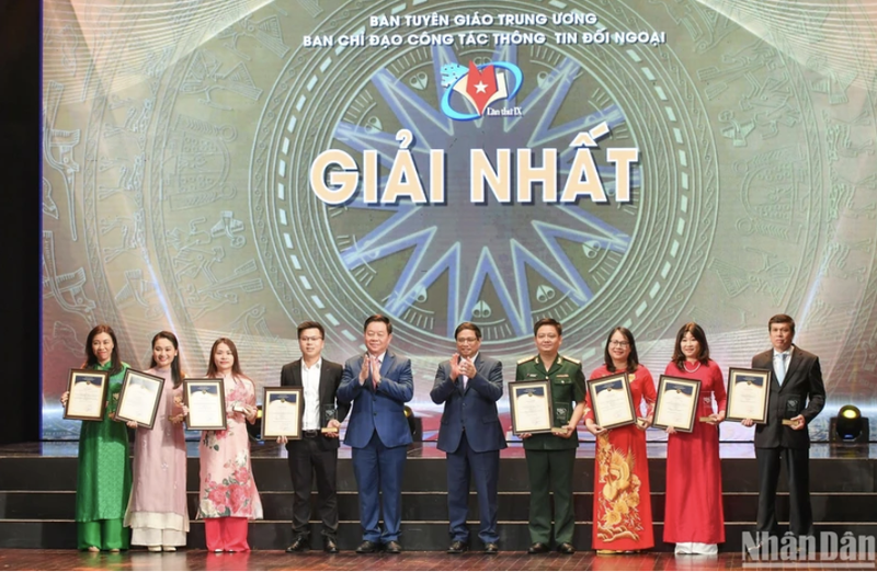El primer ministro vietnamita, Pham Minh Chinh, y el jefe de la Comisión de Comunicación y Educación del Partido y del Comité Directivo del Servicio de Información al Exterior, entregan el primer premio a los autores. (Foto: Thanh Dat)