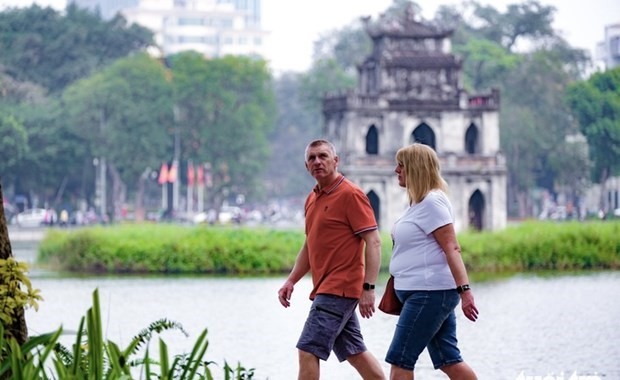 Turistas extranjeros pasean por el lago Hoan Kiem, en Hanoi (Foto: tuoitre.vn)