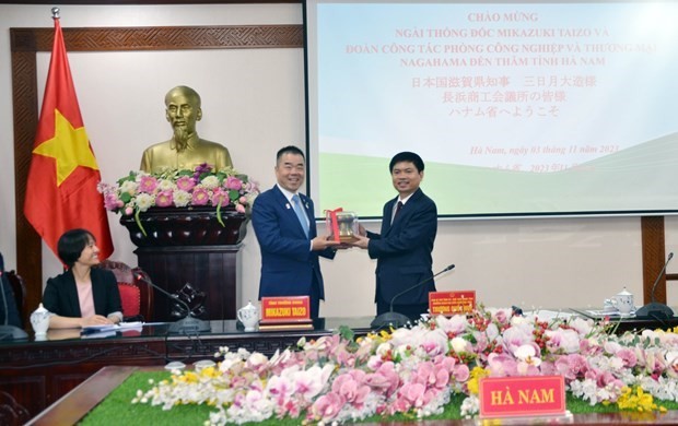 El presidente del Comité Popular de Ha Nam, Truong Quoc Huy (derecha), entrega un regalo al gobernador de la prefectura de Shiga, Mikazuki Taizo. (Foto: VNA)
