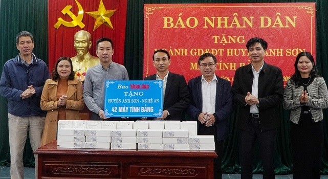 el jefe de la oficina del periódico Nhan Dan, Vu Hoang Vinh, entrega 42 tabletas al distrito Anh Son.