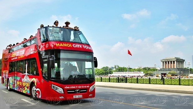 Turistas extranjeros participan en un recorrido en autobús de dos pisos por Hanoi (Foto: VNA) 