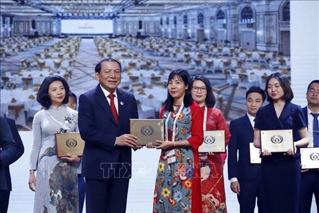 El ministro de Cultura, Deportes y Turismo de Vietnam, Nguyen Van Hung, entrega un premio al representante de una unidad vietnamita en el evento. (Foto: VNA)