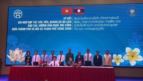 La firma de un acuerdo de cooperación entre unidades de Hanoi y Vientiane en marzo de 2024 en Laos. (Foto: VNA)
