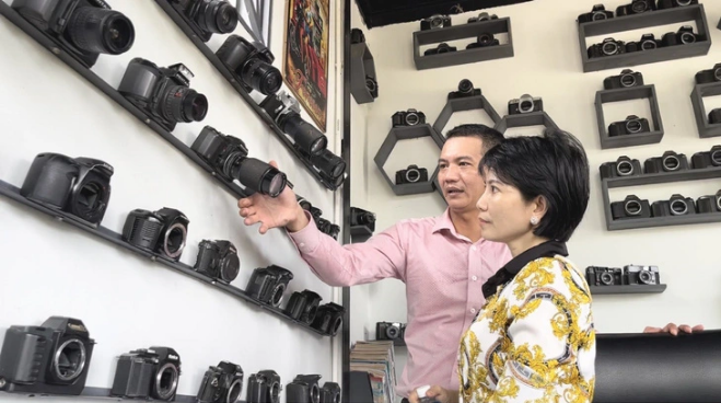 A visitor learns about the cameras on display at Like Coffee and Tea on Le Hong Phong Street, Nga Bay City, Hau Giang Province, southern Vietnam. (Foto: Tuoitre.vn)