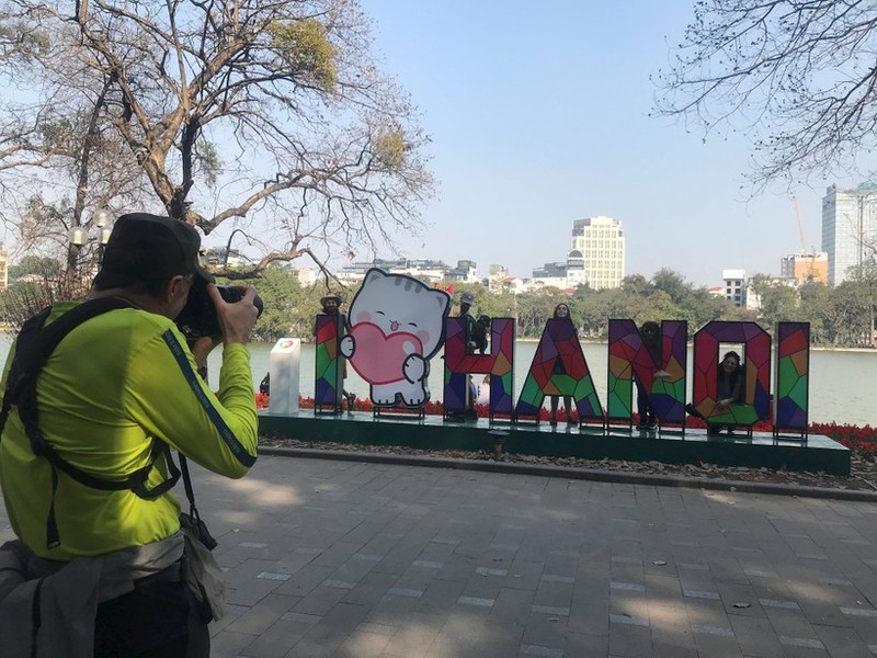 Turistas extranjeros en el lago Hoan Kiem, en Hanói (Foto: daidoanket.vn)