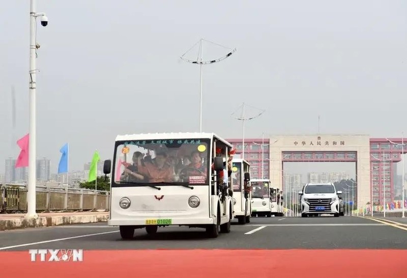 Los vehículos eléctricos que transportan a los turistas pasan por la línea divisoria del puente Bac Luan II (Foto: VNA)