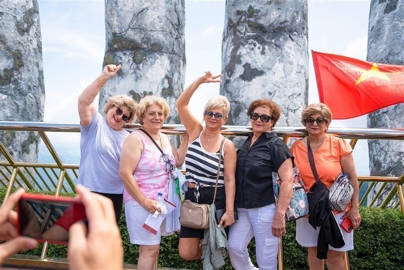 Turistas extranjeros toman fotografía en el puente dorado en Da Nang. (Foto: VNA)