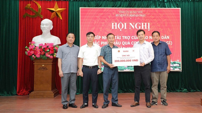 Representantes del periódico Nhan Dan entregan donaciones para apoyar a las víctimas en el distrito de Khoai Chau.