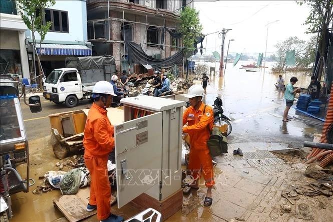 El personal de EVN repara un transformador inundado en la calle Chuong Duong Do, distrito de Hoan Kiem, Hanoi, antes de restablecer el suministro eléctrico. (Foto: VNA)