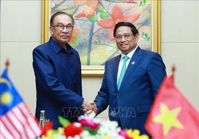 El primer ministro Pham Minh Chinh (derecha) y su homólogo malasio Anwar Ibrahim en su reunión en Vientiane el 10 de octubre. (Foto: VNA)