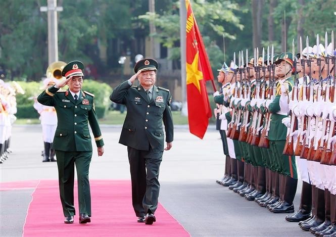 El general Phan Van Giang, subsecretario de la Comisión Militar Central y ministro de Defensa de Vietnam, y Zhang Youxia, vicepresidente de la Comisión Militar Central de China, pasan revista a la guardia de honor (Foto: VNA)