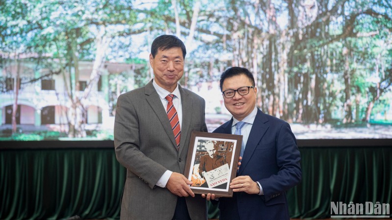 El presidente-editor del periódico Nhan Dan, Le Quoc Minh, entrega un regalo al presidente y director ejecutivo de la agencia de noticias surcoreana de Yonhap, Hwang Dae-il. (Foto: Son Tung)