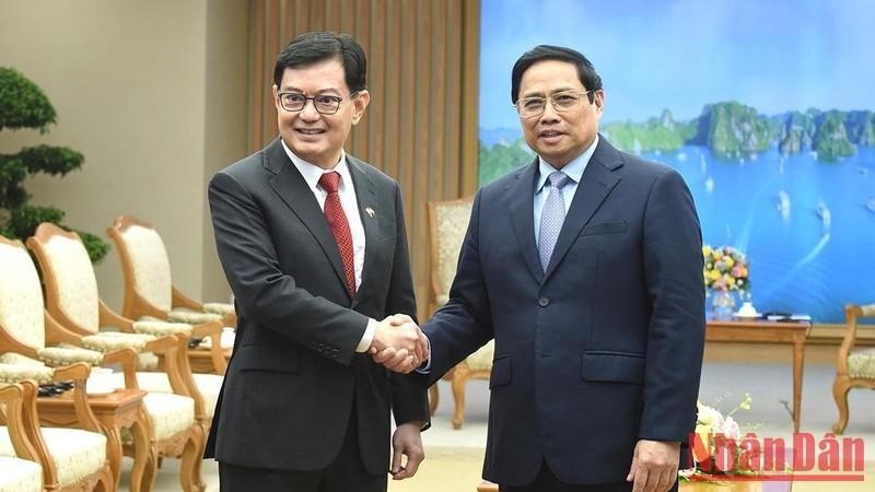 El primer ministro de Vietnam, Pham Minh Chinh (derecha), recibe al vicepremier y ministro coordinador de Políticas Económicas de Singapur, Heng Swee Keat.