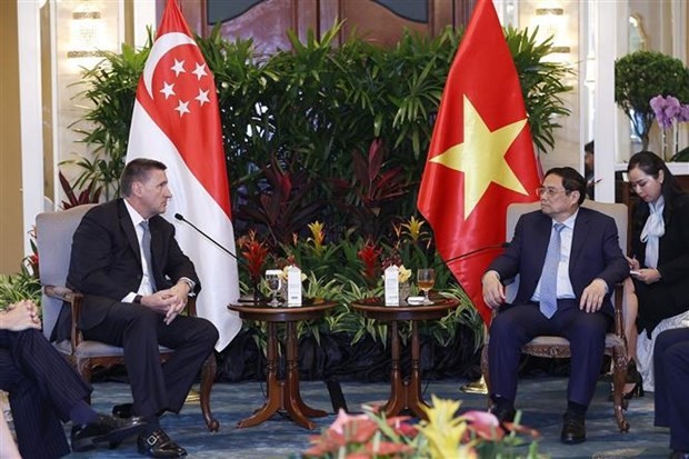 El primer ministro de Vietnam, Pham Minh Chinh (derecha), recibe a Simon Cooper, director ejecutivo a cargo de la división de banca corporativa e institucional en Europa y América de Standard Chartered. (Fotografía: VNA)
