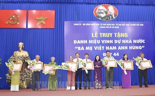 El presidente del Comité Popular de Ciudad Ho Chi Minh, Phan Van Mai, entrega título póstumo "Madres Heroicas" a representantes de las familias.(Fotografía: thanhuytphcm.vn)