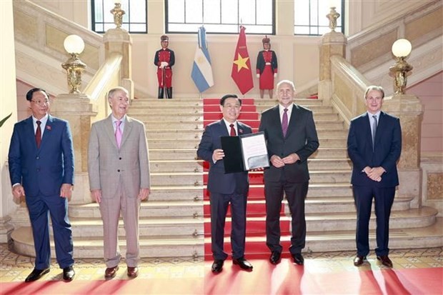 El gobernador de la provincia de Santa Fe, Omar Angel Perotti, entrega el título de Invitado de Honor al presidente de la Asamblea Nacional, Vuong Dinh Hue. (Fotografía: VNA)
