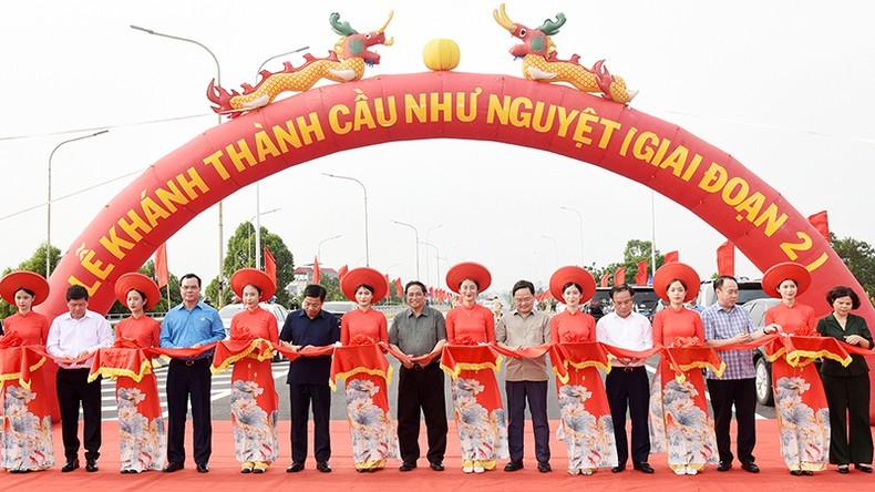 El primer ministro Pham Minh Chinh y los delegados cortan la cinta para inaugurar la segunda fase del puente Nhu Nguyet.