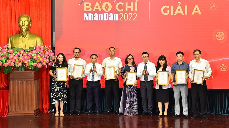 El presidente-editor del periódico Nhan Dan, Le Quoc Minh, y subredactor jefe Dinh Nhu Hoan entregan el premio A a los autores y representantes de grupos de autores. 