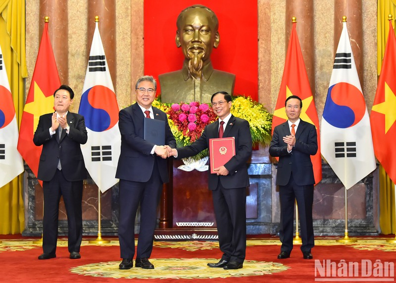El ministro de Relaciones Exteriores de Vietnam, Bui Thanh Son, y su homólogo surcoreano, Park Jin, intercambian documentos firmados sobre el programa de acción entre los dos Gobiernos relacionado con el fortalecimiento de la asociación estratégica binacional.