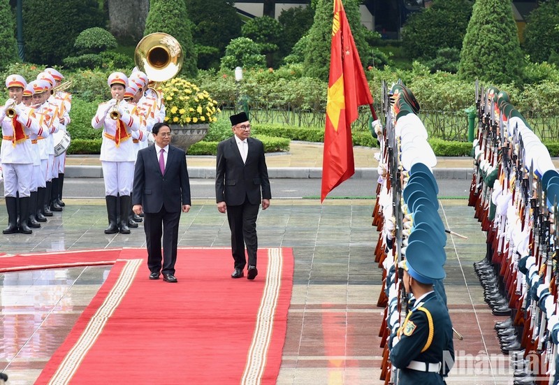 El primer ministro de Vietnam, Pham Minh Chinh, y su par malasio, Anwar Ibrahim, pasan revista a la guardia de honor.