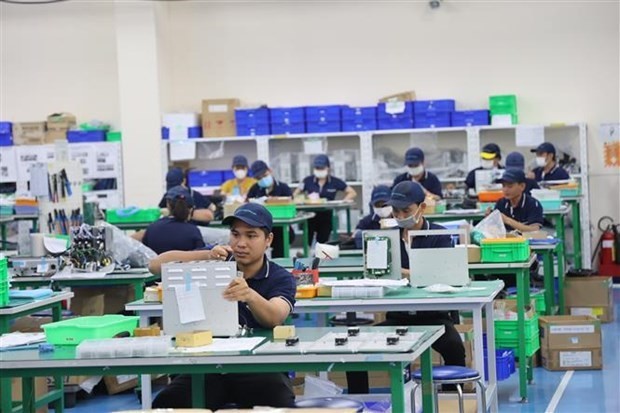 Empleados trabajan en la fábrica de Tazmo Vietnam, una empresa 100% de propiedad japonesa, ensamblando equipos de robots industriales. (Fotografía: VNA)