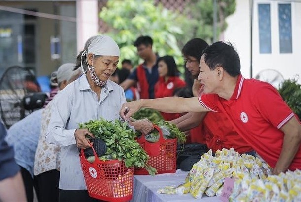 Personas compran en el mercado humanitario organizado por la Asociación de la Cruz Roja de la provincia de Hoa Binh. (Fotografía: VNA)