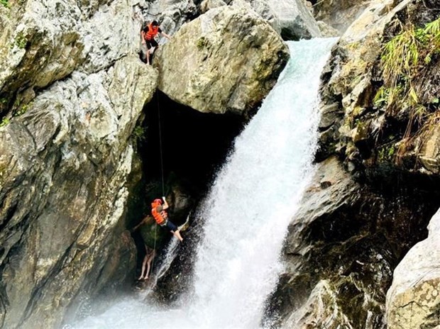 Socorristas rescatan a un extranjero atrapado en la cascada. (Fotografía: VNA)
