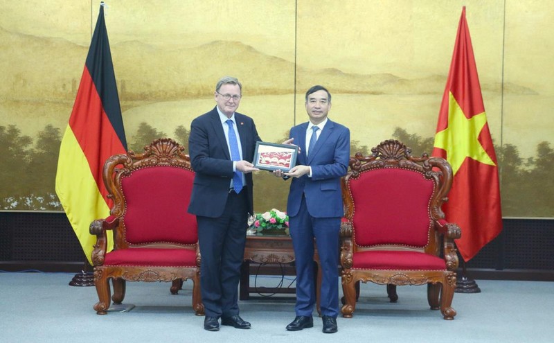 El presidente del Comité Popular de la ciudad vietnamita de Da Nang, Le Trung Chinh, entrega un regalo a Bodo Ramelow, ministro-presidente del estado alemán de Turingia. (Fotografía: cadn.com.vn)