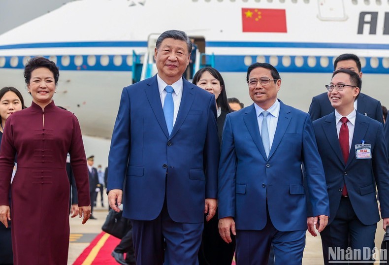 Pham Minh Chinh, miembro del Buró Político y primer ministro de Vietnam, da la bienvenida a Xi Jinping, secretario general del PCCh y presidente de China, en el Aeropuerto Internacional de Noi Bai.