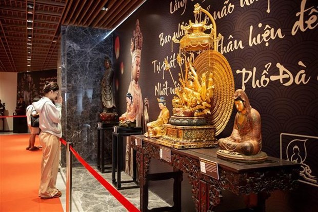 Turistas visitan la antigua estatua de Buda en el área de exposición sobre el Budismo en la cima de la montaña Ba Den. (Foto: VNA)