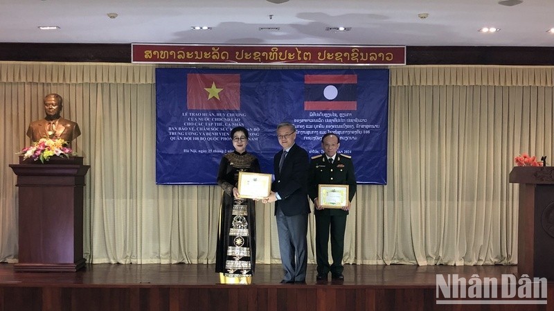 El jefe de la Comisión de Relaciones Exteriores del Comité Central del Partido Revolucionario Popular de Laos, Thongsavanh Phomvihane, entrega la Orden de la Amistad a individuos vietnamitas. 