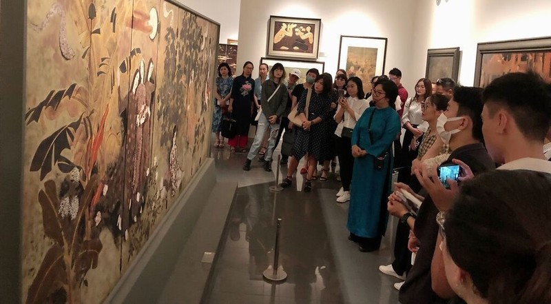 Los turistas conocen las obras durante el recorrido sobre pintura de laca en el Museo de Bellas Artes de Vietnam (Foto: VNA)