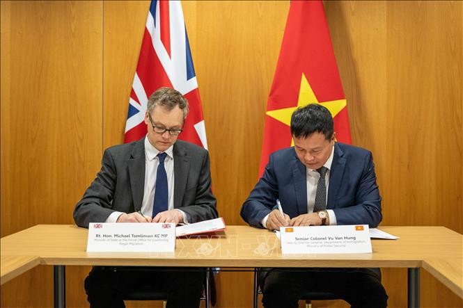 El coronel Vu Van Hung (derecha) y el ministro de Lucha contra la Migración Ilegal del Reino Unido, Michael Tomlinson, firman en Londres la Declaración Conjunta sobre cooperación para prevenir la migración ilegal. (Foto: Ministerio del Interior británico)