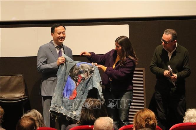 El embajador de Vietnam en Italia, Duong Hai Hung, recibe en nombre del equipo de filmación el premio al mejor largometraje por la película "Ben trong vo ken vang". (Foto: VNA)