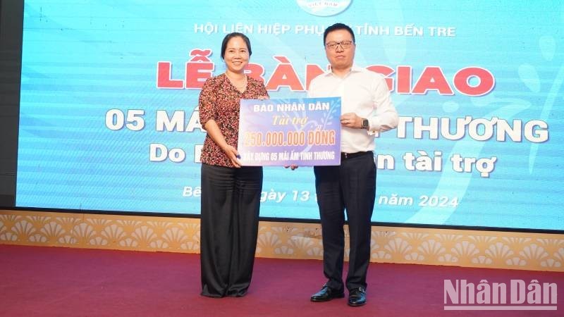 El presidente-editor de Nhan Dan, Le Quoc Minh, entrega un simbólicamente el apoyo a la Unión de Mujeres de la provincia de Ben Tre.