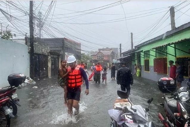 El personal de la guardia costera evacua a niños de una zona inundada en Lucena, provincia de Quezón, Filipinas, en medio de las fuertes lluvias provocadas por la tormenta tropical Ewiniar. (Foto: philstar.com)