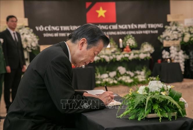 Presidente del Partido Nuevo Kōmeitō de la coalición gobernante de Japón, Natsuo Yamaguchi, escribe en el libro de condolencias. (Foto: VNA)