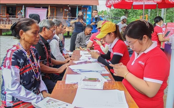 Los pobladores de la minoría étnca de Co Tu configuran sus nuevos celulares (Foto: VNA)