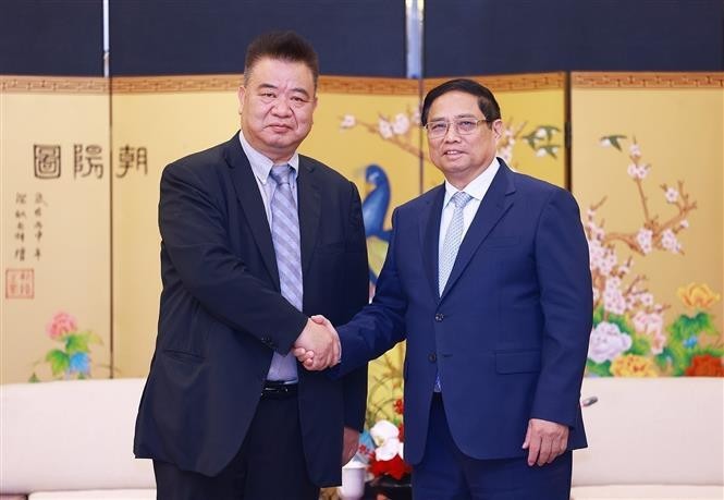 El primer ministro de Vietnam, Pham Minh Chinh y Cao Ronggen, presidente del Centro Internacional de Subastas de Flora de Kunming (KIFA) (Foto: VNA)