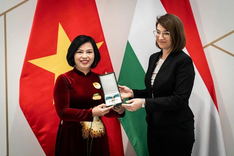 La secretaria de Estado de Relaciones Bilaterales del Ministerio de Asuntos Exteriores y Comercio Exterior de Hungría, Illés Boglárka, entrega la Cruz de la categoría de Oficial de la Orden del Mérito a la embajadora vietnamita en Budapest, Nguyen Thi Bich Thao. (Foto: VNA)