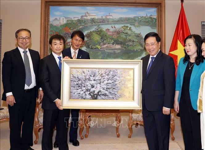 El viceprimer ministro Pham Binh Minh (cuarto de iquierda a derecha) recibe un obsequio del presidente del Grupo EMS, Matsuoka Yoshinori (Fotografía: VNA)