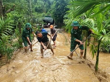 Los oficiales y soldados de guardia fronteriza ayudan a las personas a superar las consecuencias de las inundaciones. (Fotografía: VNA)