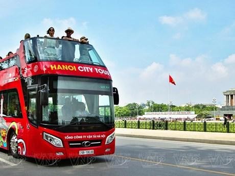 Turistas extranjeros en un autobús de dos pisos disfrutan del paisaje del Mausoleo dedicado al Presidente Ho Chi Minh y la plaza Ba Dinh (Fotografía: VNA)