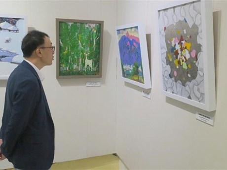 Un ciudadano surcoreano contempla obras exhibidas en el evento. (Fotografía: VNA)