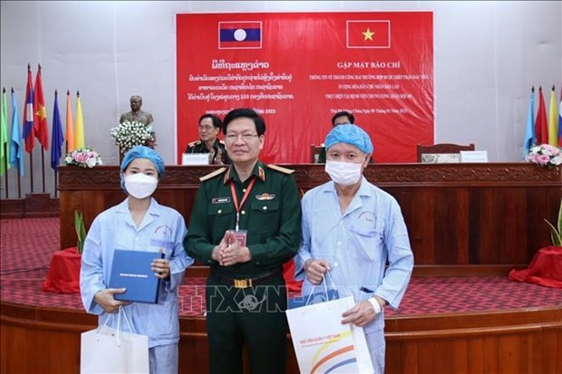 Nguyen Xuan Kien, director de la Academia de Medicina Militar de Vietnam, entrega obsequios a los dos pacientes laosianos. (Fotografía: VNA)