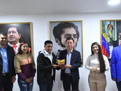 El profesor asociado, doctor Vu Trong Lam entrega el logo de la Revista Comunista al vicepresidente de la organización del PSUV y vicepresidente de la Asamblea Nacional de Venezuela Pedro Infante. (Foto: VNA)