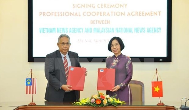 Directora general de VNA, Vu Viet Trang, y el editor en jefe de BERNAMA, Khairdzir bin Md Yunus, firmaron un acuerdo de cooperación profesional. (Foto: VNA)