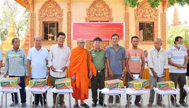 El primer coronel Le Thanh Hung entrega obsequios a los pobladores del distrito de Vinh Loi. (Foto: VNA) 